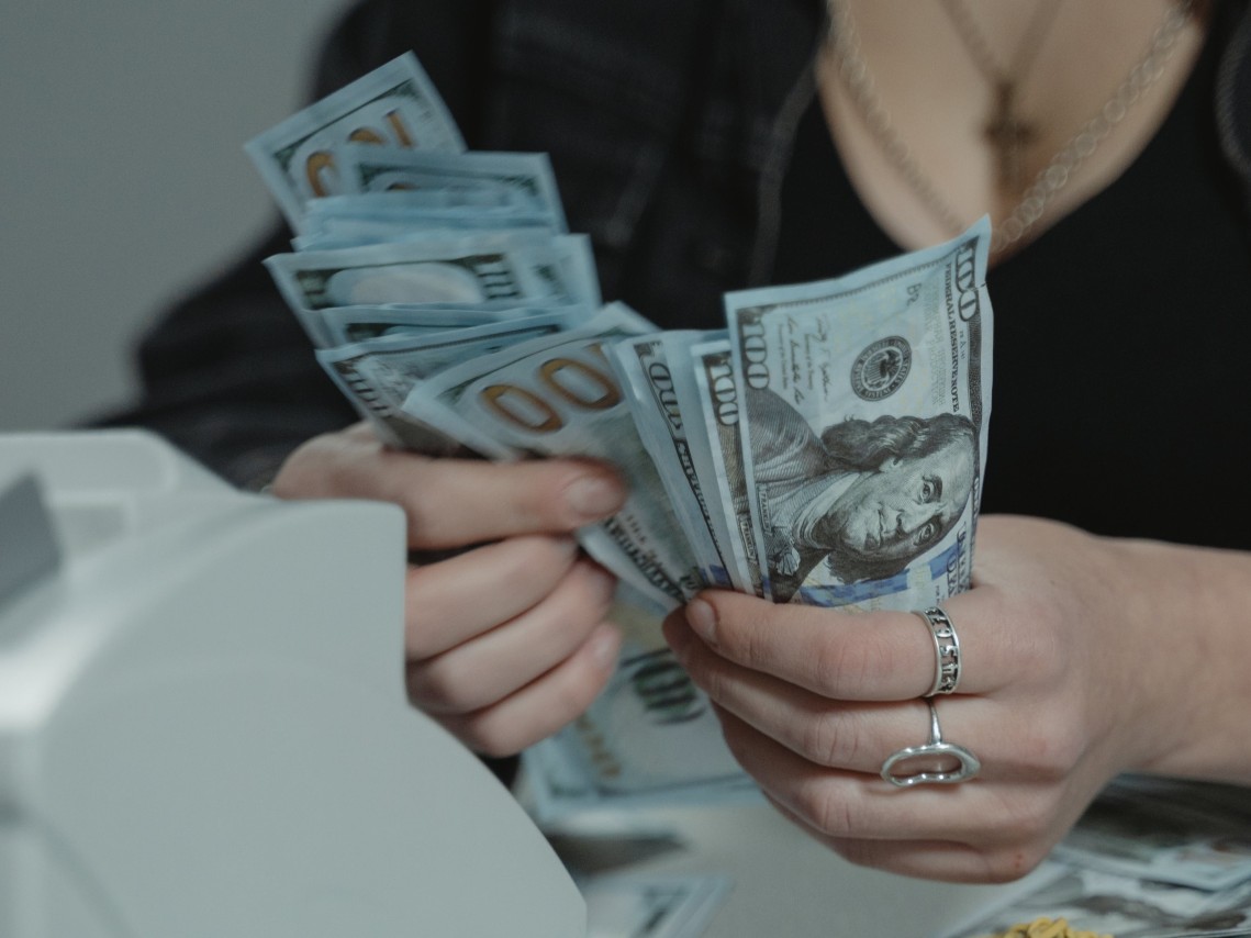 Woman counting Hundred dollar bills